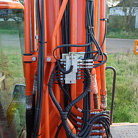Progressivverteiler montiert an einer Baumaschine Progressivverteiler einer Zentralschmierung an einer Baumaschine
